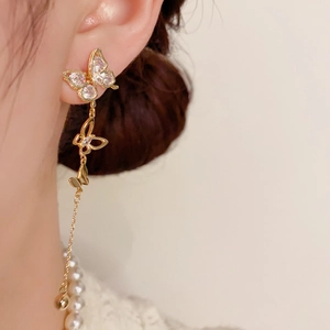 Detail of luxury gold butterfly tassel earrings with sparkling rhinestones on a model