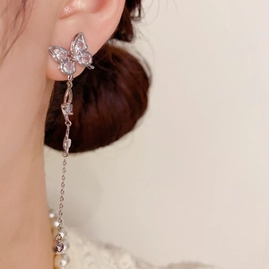 Elegant silver butterfly tassel earrings with sparkling rhinestones on female model