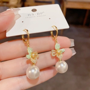 Elegant gold butterfly earrings with zircon crystals and large round white pearls
