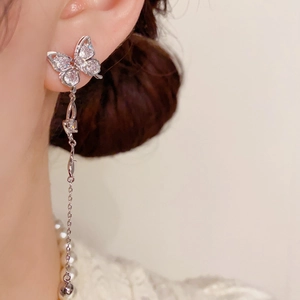 Macro shot of silver butterfly tassel earrings with sparkling crystals for elegant style