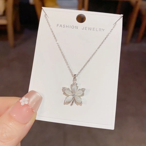 Detail view of flower pendant necklace with shell inlay and micro-paved zircons