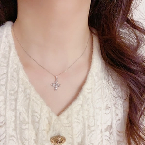 Collier pendentif croix argenté avec cristaux sur chaîne délicate porté par un mannequin