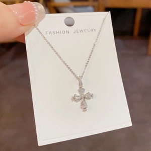 Gros plan du pendentif croix étincelant avec cristaux sur un collier en argent poli