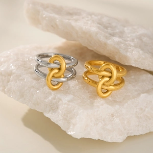 Detail of 18k gold plated double layer rings with interlocking circles on marble display