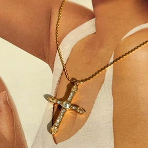 Detail of 18k gold plated cross pendant with shimmering rhinestones and bead chain