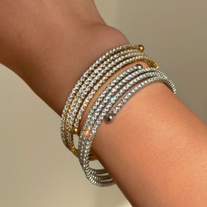Detail of multi-layered 18k gold and silver plated bangles with pave-set cubic zirconia