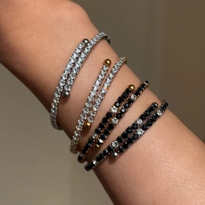 Stacked 18K gold and silver plated tennis bracelets with black and white crystals