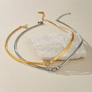 Platte slangenketting set met drie zirkonia-stenen op een witte stenen basis