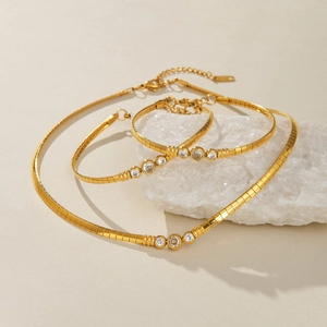 Detail van 18k vergulde vintage slangenketting set met zirkoonstenen op stenen basis