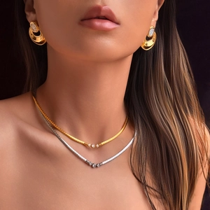 Detail van 18k vergulde chokers en oorbellen met diamanten gedragen door een model