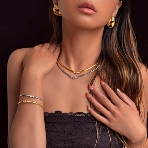 Detail van een 18k vergulde choker en edelsteen oorbellen gedragen door een model