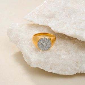 Macro detail of 18k gold plated sun signet ring with engraved silver center disk