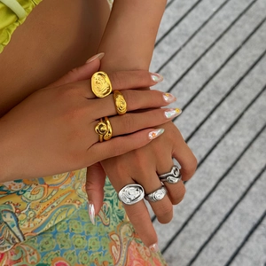 Detail van onregelmatige vloeibare metalen ringen met lavatextuur in goud en zilver
