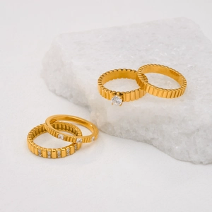 Close-up van vierdelige 18k vergulde titanium ringenset met glinsterende zirkoonstenen