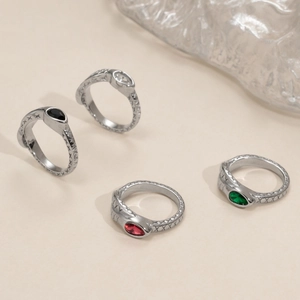 Detail of four retro silver rings with colorful teardrop stones and vintage carvings