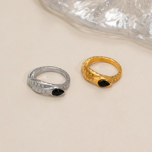 Macro detail of 18k plated snake ring with scale texture and black teardrop gemstone
