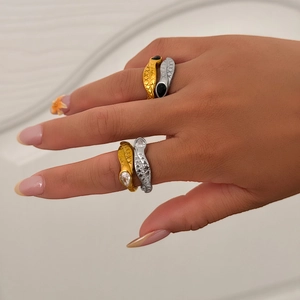 Detail of 18k gold and silver snake rings with scale texture and gemstone eyes