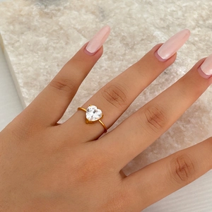 Elegant 18k gold plated titanium ring with a large heart-shaped cubic zirconia on model hand