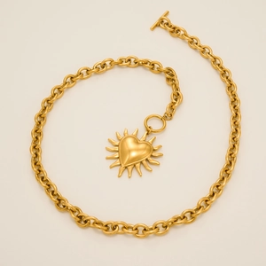 Dettaglio della collana a catena dorata 18k con pendente sole cuore e chiusura a T