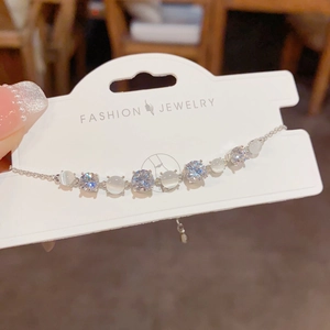 Detailed shot of cat eye stone and cubic zirconia bracelet on display card