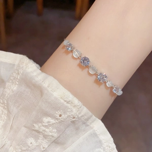 Elegant silver bracelet with alternating cat eye stones and clear zircons on wrist