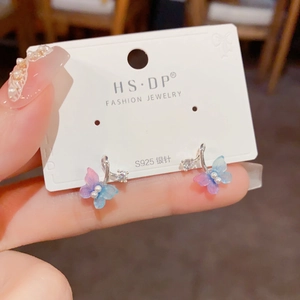 Macro shot of S925 silver needle butterfly earrings with blue-purple gradient and tiny pearl