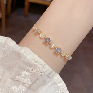 Detailed shot of cat eye stone bracelet with sparkling zircons on woman wrist
