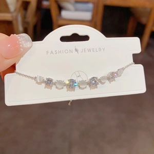 Elegant silver bracelet with cat-eye stones and zircons on fashion jewelry card