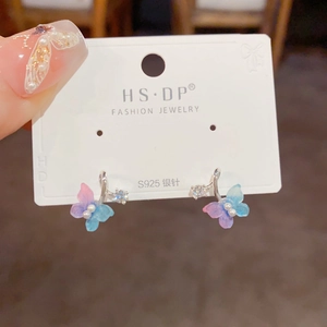 Macro shot of S925 silver butterfly earrings with pink-blue gradient wings and pearl accents