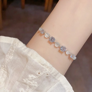 Close-up of cat eye stone and zircon bracelet worn on wrist for elegant style