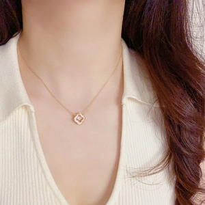 Détail du collier trèfle doré avec pierre de zircon porté sur un modèle