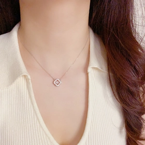 Gros plan détaillé d'un collier trèfle à quatre feuilles en argent sur un mannequin