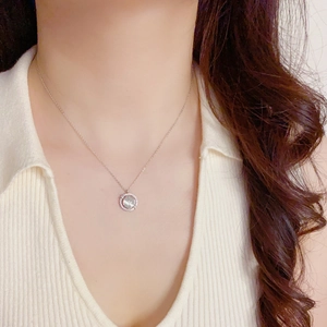 Detail of a rotating cat's eye stone necklace with crystal pave on a model's neck