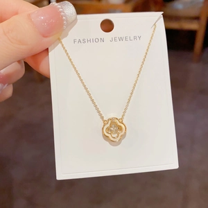 Détail du pendentif fleur à quatre feuilles en or avec incrustation nacre et zircon