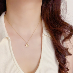 Elegant gold necklace with cat eye stone pendant and zircon accents on female model
