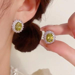 Gros plan sur d'élégantes boucles d'oreilles en zircon jaune avec halo de diamants