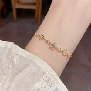 Detail of star and moon gold bracelet with sparkling zircon and pearl inlay on wrist