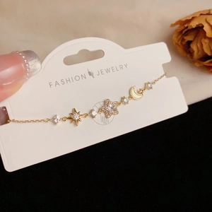 Detailed macro shot of a star and moon bracelet with sparkling pave zircon charms