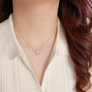 Elegante gouden cilinder ketting met volledige diamantzetting en drie hangende bedeltjes