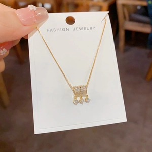 Macro-opname van gouden kwastjesketting met sprankelende cilinders en zirkonia-hangers