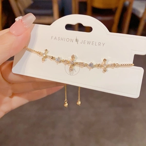 Detailed shot of a gold cross bracelet with blue stones and white zircon accents