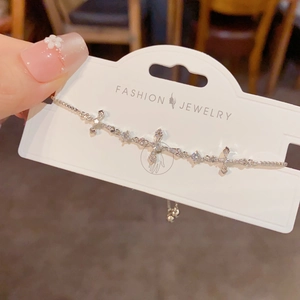 Close-up of silver cross bracelet with cubic zirconia and adjustable pull chain slider