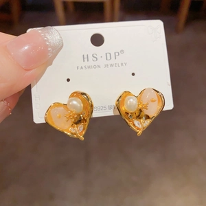 Détail de la boucle d'oreille cœur doré avec perle et tige en argent S925