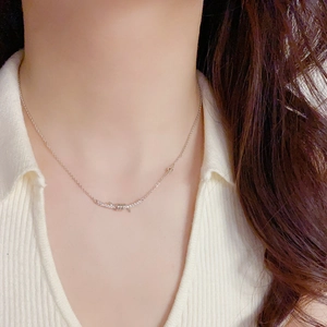 Close-up of a silver barbed wire pendant necklace with sparkling zircons on a model
