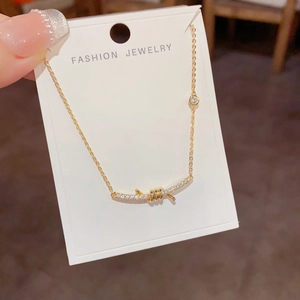 Detail of gold smile necklace featuring pavé-set diamonds and unique knotted spiral design