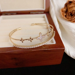 Close-up of double-layer open bangle with sparkling clover motifs and zircon inlay