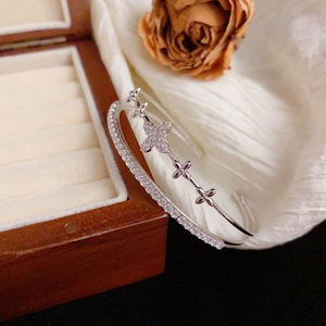 Detail of a double-layer silver bangle with sparkling floral motifs and pave diamonds
