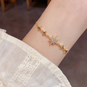Élégant bracelet étoile polaire dorée avec zircons brillants sur le poignet d'une femme