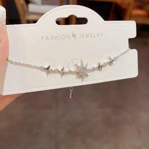 Détail d'un bracelet d'étoiles argentées avec pendentif brillant sur carte bijou