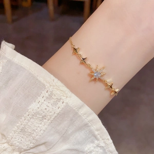 Vue détaillée d'un bracelet étoilé doré avec zircon étincelant porté au poignet